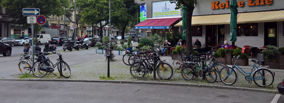 Fahrräder stehen an Bäumen, Straßenschildern oder Pfosten.